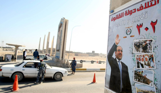 Image: An Iraqi officer checks the IDs of passengers