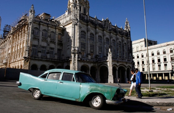 Image: People walk by a classic car parked outside the Revolution Museum in Havana
