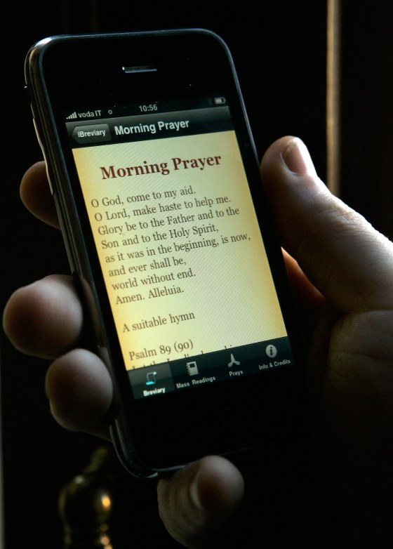 Image: Father Paolo Padrini holds up his I-Breviary