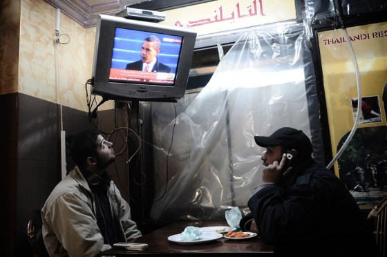 Image: Palestinian youths watch the live televised inauguration ceremony for US President Barack Obama
