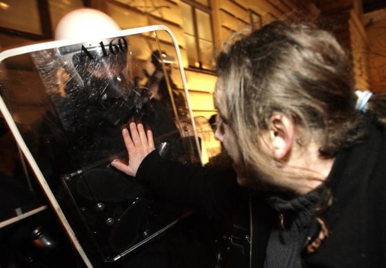 Image: A man argues with riot police in front of Latvia's Parliament building in Riga