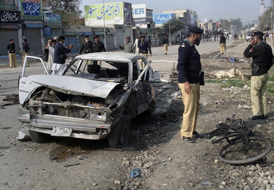 Image: Pakistani police officers examine the site of bomb explosion