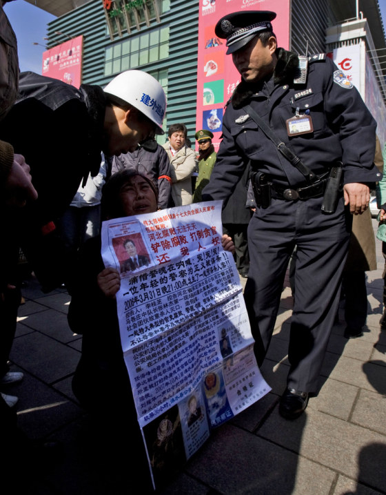 Image: A woman protesting against corruption outside a shopping mall in Beijing