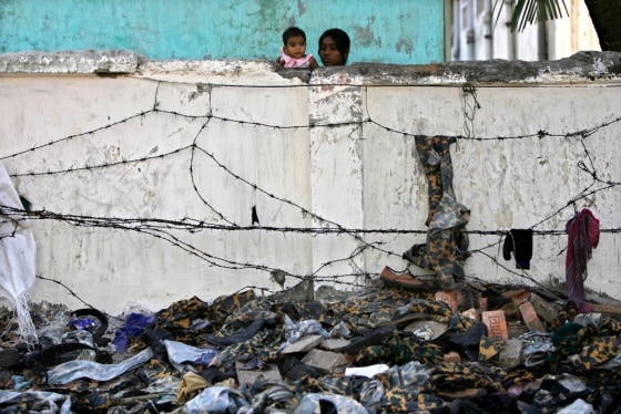 Residents watch the ambandoned uniforms of the rebel Bangladesh Rifles members inside the BDR headquarters in Dhaka.