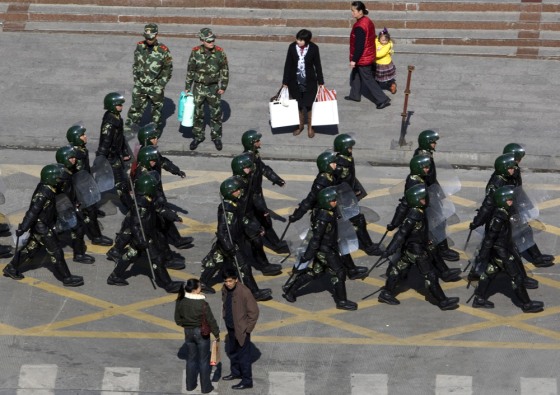 Image: Heavily armed paramilitary police patrol a street of Kangding