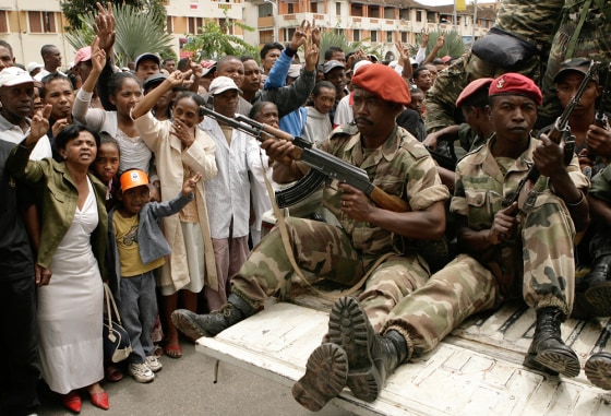 Image: Opposition supporters wave at Malagasy soldiers at the end of a religious service at Antananarivo's city centre