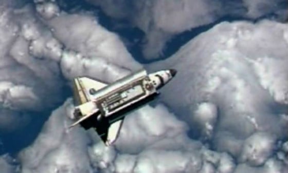 Image: The Space Shuttle Discovery is backdropped against the clouds prior to docking with the International Space Station