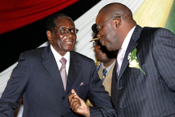 Image: Zimbabwe's President Robert Mugabe talks to Finance Minister Tendai Biti