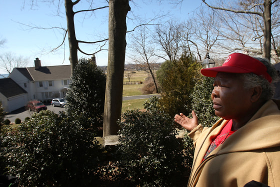 Image: Emeline Bravo-Blackwood, a gardener, stands in front of the home of James Haas, one of numerous executives who were recipients of a bonus from American International Group Inc.