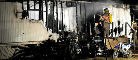 Firefighters investigate the scene of a fatal fire on Saturday, near St. Paris, Ohio. The state fire marshal's office says four children have been killed in a mobile home fire in Champaign County.