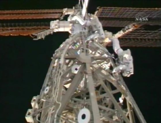 Astronauts Joseph Acaba and Steve Swanson work on cargo attachment system in this image from NASA TV