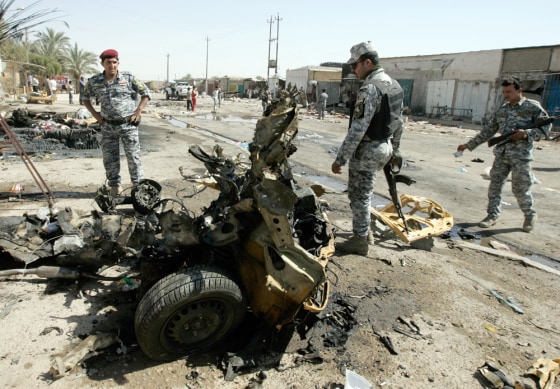Image: Policemen inspect the wreckage of a vehicle used in a car bomb attack in Baghdad