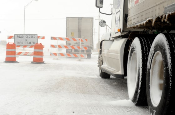 Image: Semi trucks sit behind barricades on the access road to Interstate 40 from Soncy Road in Amarillo, Texas.
