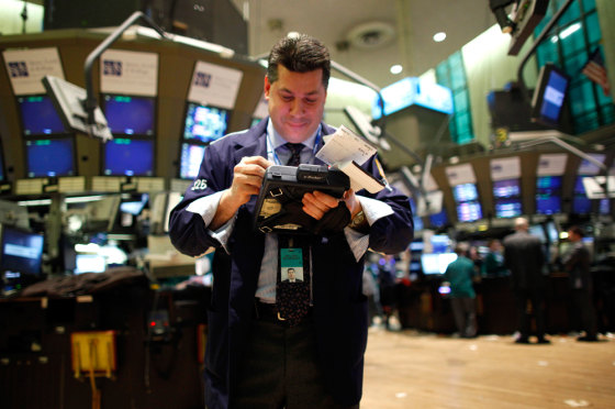 Image: A trading specialist uses his handheld computer on the floor of the New York Stock Exchange