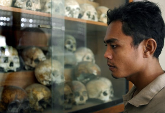 Image: A Cambodian man looks at skulls of the Khmer Rouge victims at Tuol Sleng Genocide museum