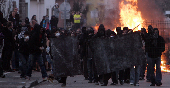 Image: Activists block a road close to the camp of anti-NATO activists