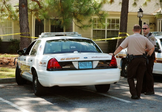 Two deputies stand guard outside an apartment complex Aug. 21, 2008, where five men were found dead in Columbiana, Ala. Investigators believe the slayings were related to a drug debt involving a Mexican drug organization.