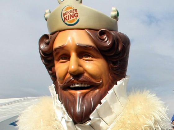 The Burger King mascot stands outside t