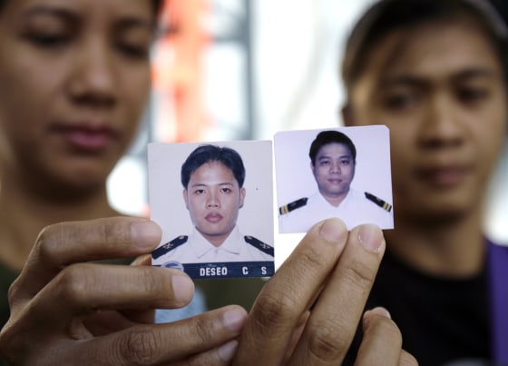 Image: Families of hostages show their photos.