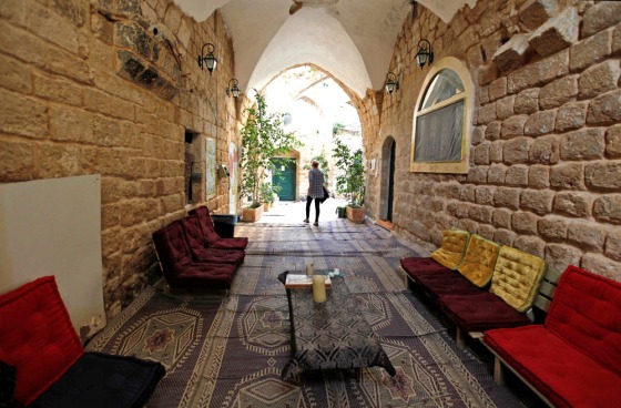 Image: tourist walks out of her room at the Fauzi Azar Inn