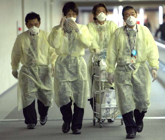 Image: Quarantine officers walk to airplanes arriving from Mexico