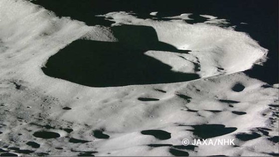 A large crater reveals the harsh light and shadow created on the lunar landscape as sunlight fight no atmosphere.