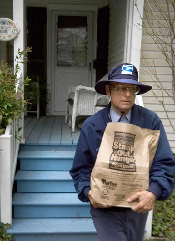 Mail carrier Scott Smith collects donated food from a home on Beardsley Avenue in Elkhart as part of the National Association of Letter Carriers Food Drive on May 9.