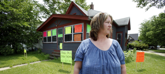 Image: Jaylynn Banks stands in front of her old home which flooded a year ago in Cedar Rapids, Iowa.