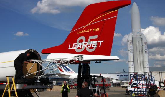 Image: Workers install the tail section on a mockup of a Learjet 85 jet at Le Bourget airport near Paris