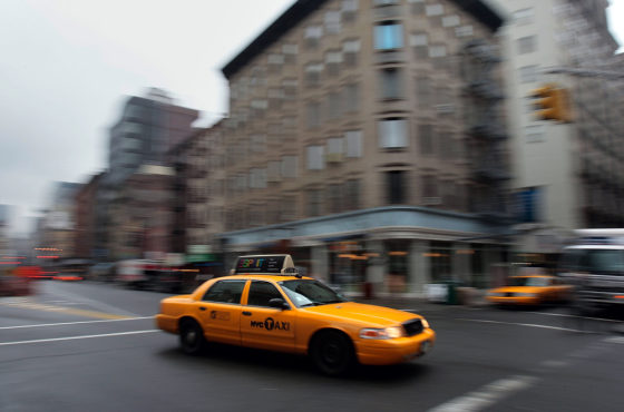 Image: A taxi drives through a downtown Manhattan