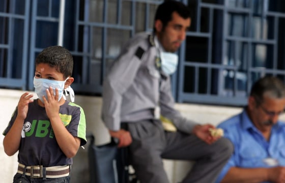 Image: Jordanian boy puts on his mask in Amman, Jordan