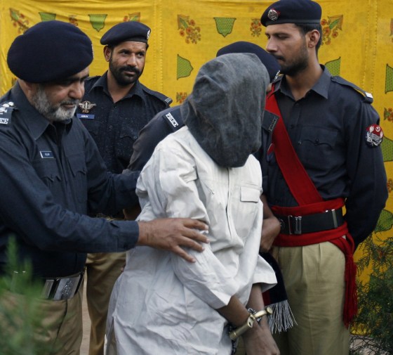 Image: Policemen escort a detained man to showcase before the media in Sri Lanka