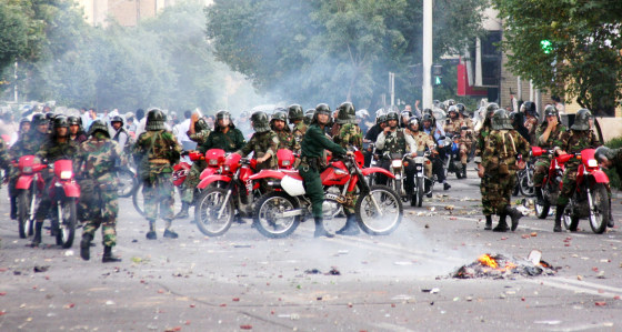 Image: Iranian police sit on motorcycles as they face protesters during a demonstration in Tehran