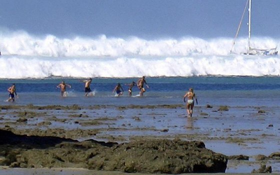 Image: Tourists caught run from a wave caused by a tsunami at Hat Rai Lay Beach, near Krabi in southern Thailand.