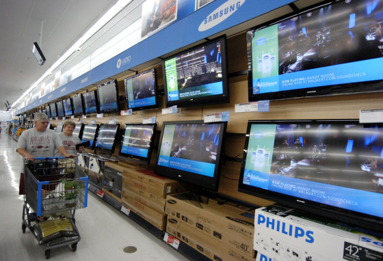 Image: Shoppers walk past televisions on display in the electronics department of a Wal-Mart store in Rogers, Ark.