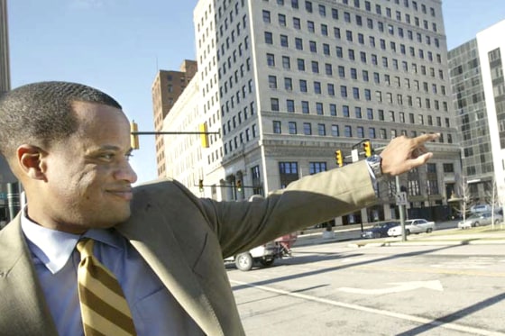 Mayor Jay Williams waves to a passerby in downtown Youngstown in this 2008 file photo. Williams calls the headway made by the city's demolition crews in demolishing vacant and abandoned buildings one of the most tangible successes to date.