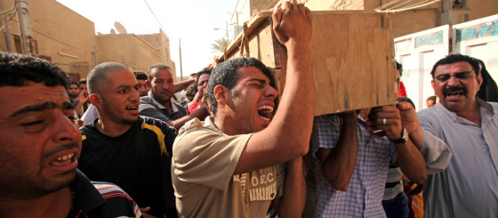 Image: Men carry the coffin of a relative killed in a bombing in the main Shiite district in Baghdad.