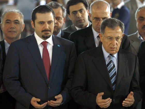 Image: Outgoing Lebanese prime minister Fuad Siniora (R) and premier-designate Saad Hariri pray over the tomb of the latter's father, slain former prime minister Rafiq Hariri