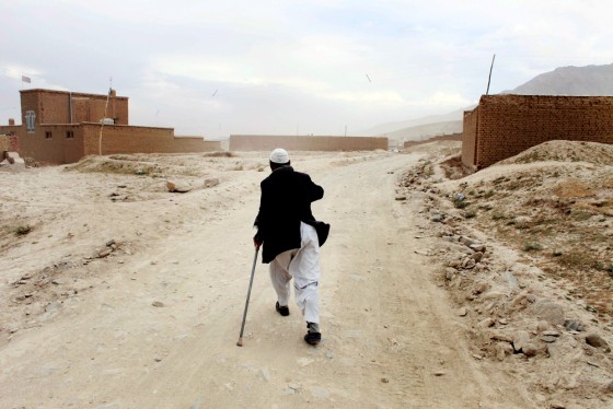 Image: Yosouf, 48, who lost a leg to a land mine while fighting against the Russian in Ghazni province, walks to his home