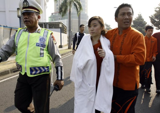 Image: An injured victim is evacuated by police officers after a bomb blast hit Ritz Carlton hotel in Jakarta