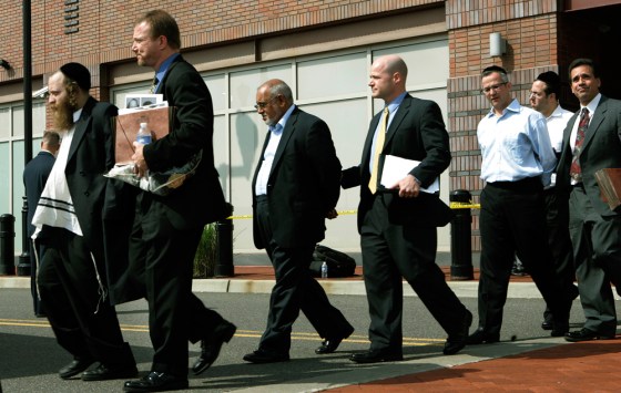 Image: A group of men in custody walk outside the Newark, NJ FBI office.