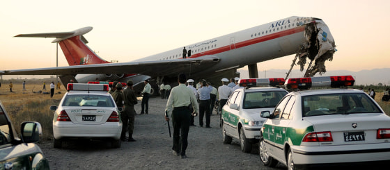 Image: crews clean up after a Iranian jet crash