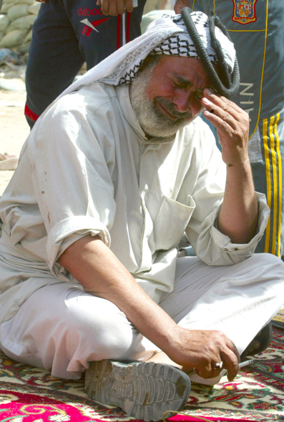 Image: Man reacts upon hearing news of deaths of his friends who were killed in car bomb attack in Baghdad's Shaab District