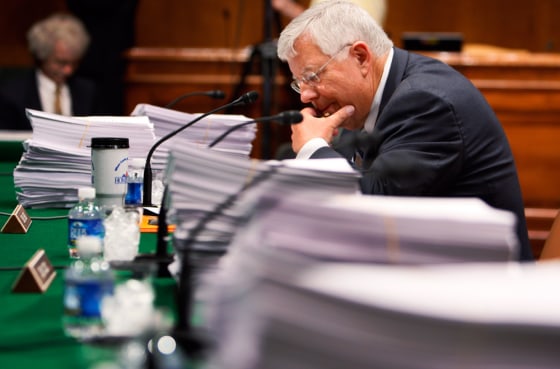 Image: Sen. Mike Enzi pores over copies the health care reform bill