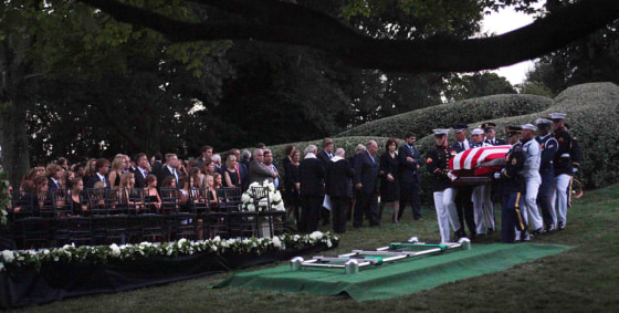 Image: The Kennedy family gathers around the grave site as an Honor Guard carries the casket of Sen. Ted Kennedy at Arlington National Cemetery, in Arlington, Va.