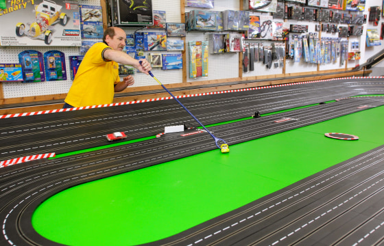 Image: Chris Fine of Mid-Hudson Hobbies reaches for a slot car