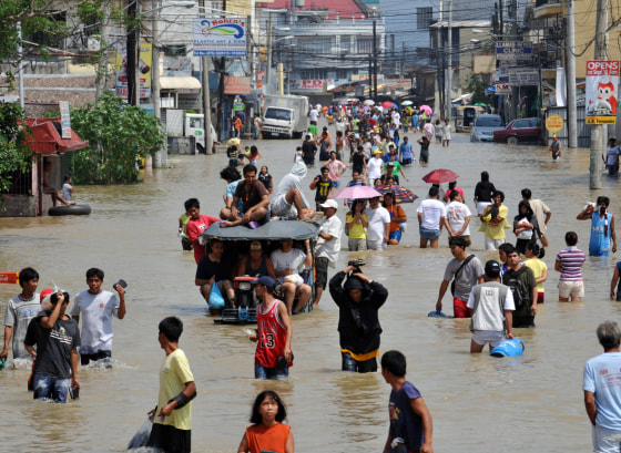 Image: Residents walk through a flooded street