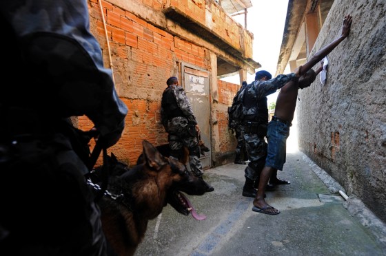 Image: Police frisk a man as they search for drugs and weapons in the Morro do Adeus slum