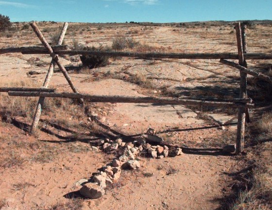 Image: A cross made of stones rests below the fence in Laramie, Wyoming
