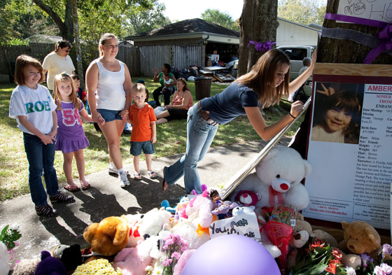 Image: neighbors pay respects at a memorial to Somer Thompson